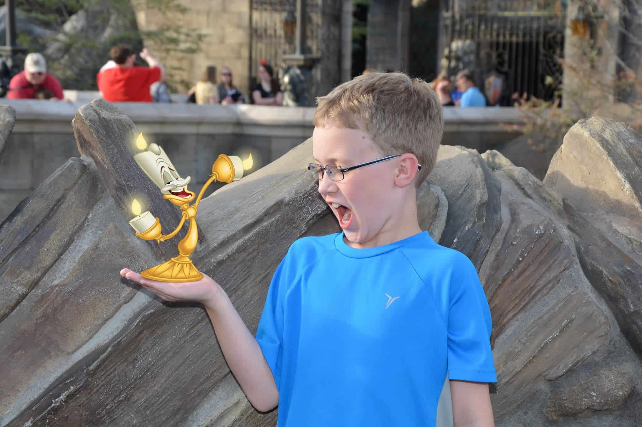 menino segurando candelabro animado na mão em foto tirada pelo Photopass no pacote memory maker disney
