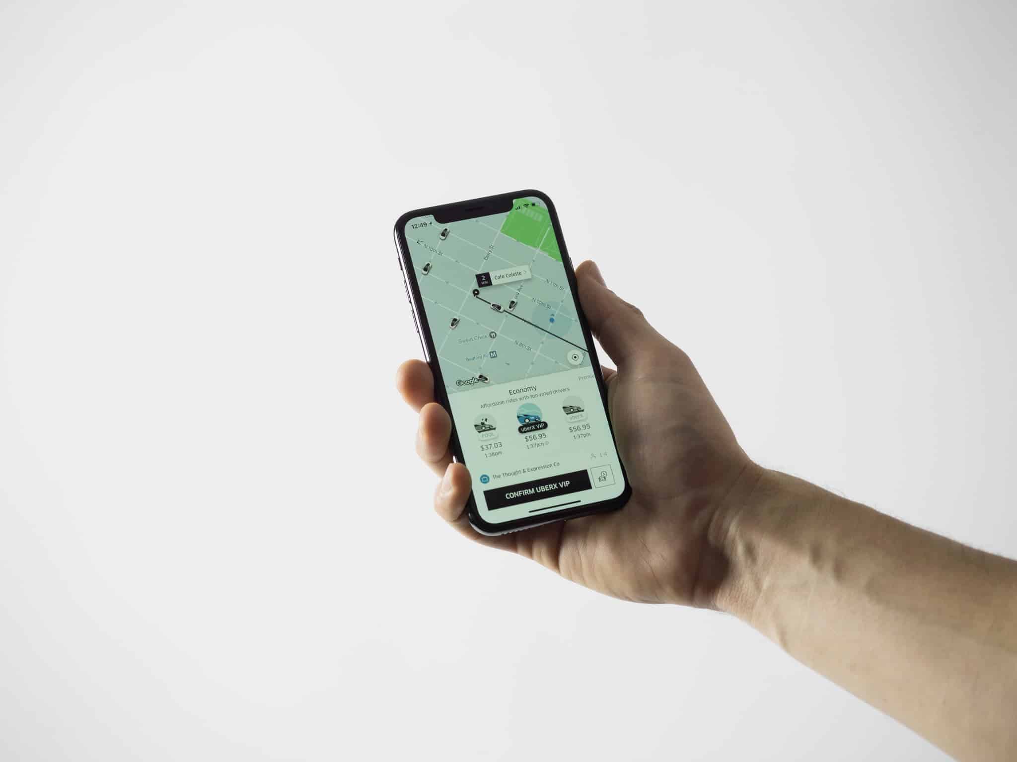 pessoa segurando celular com app do uber aberto
